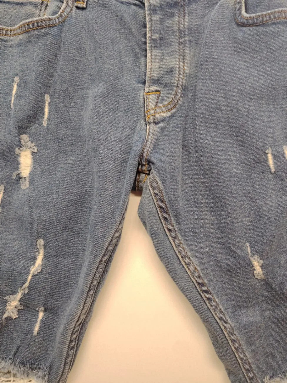 Damen blue skinny jeans with ripped details, five-pocket style, and classic button closure.