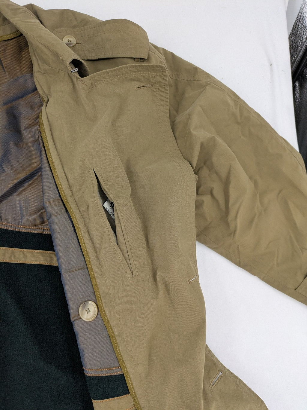 Studio Novum khaki trench coat double-breasted design with belt and wool lining.