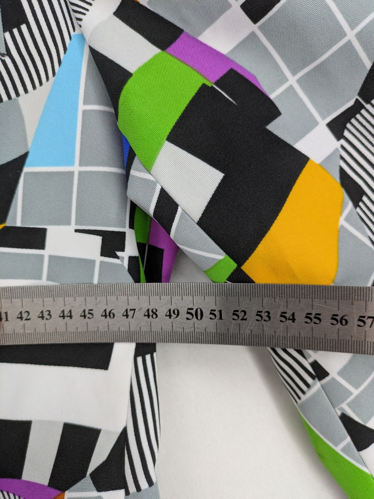 Opposuits blue and green blazer with vibrant geometric pattern and purple satin lining.