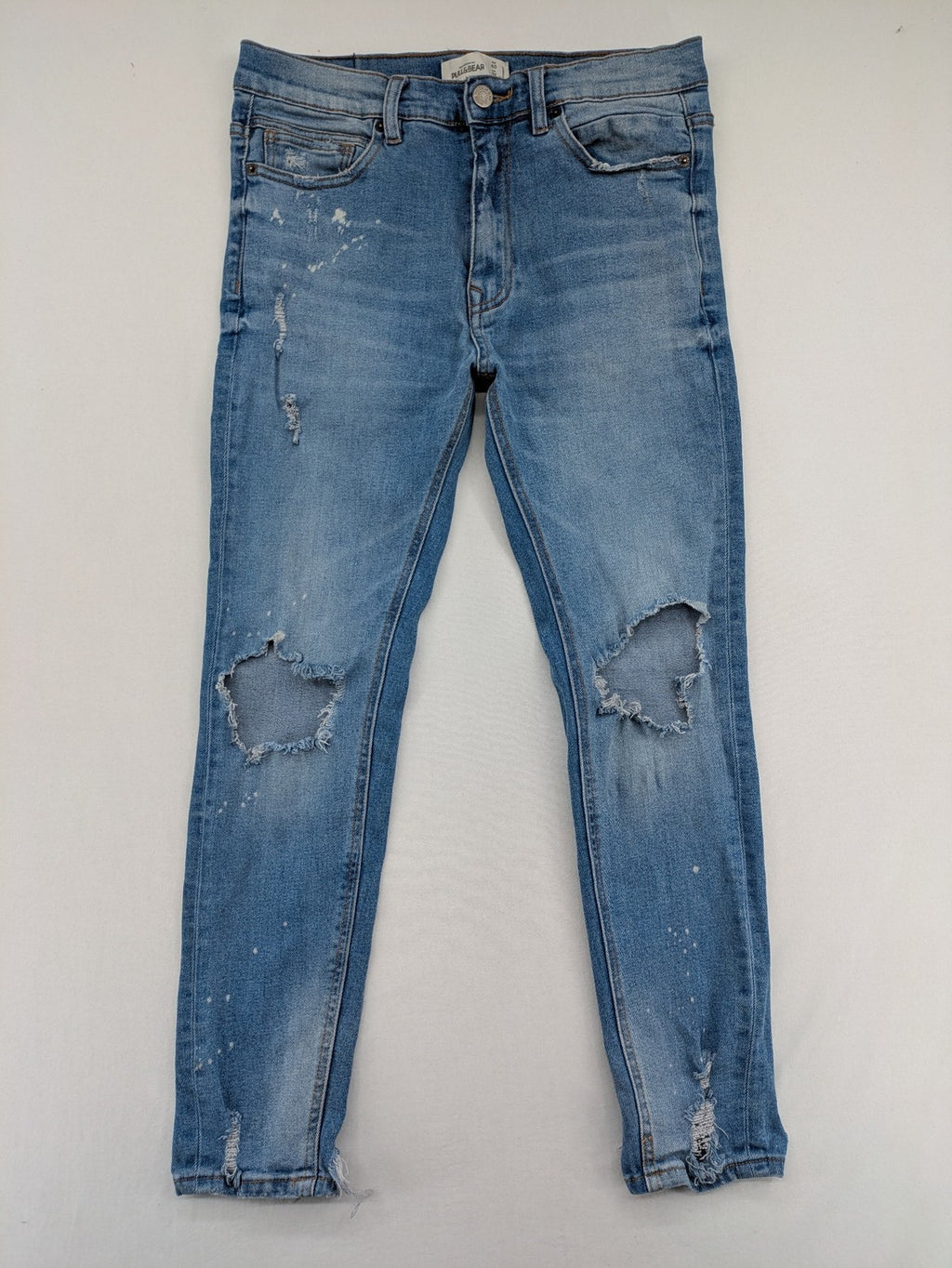 Pull&Bear blue carrot fit jeans with distressed knees and frayed hems.