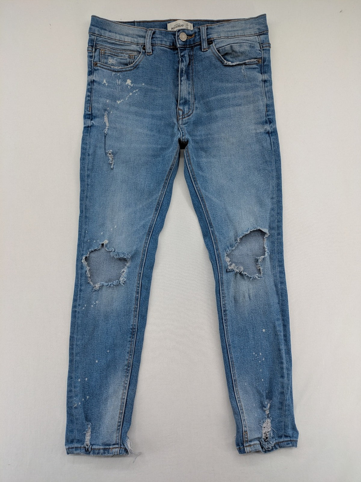 Pull&Bear blue carrot fit jeans with distressed knees and frayed hems.