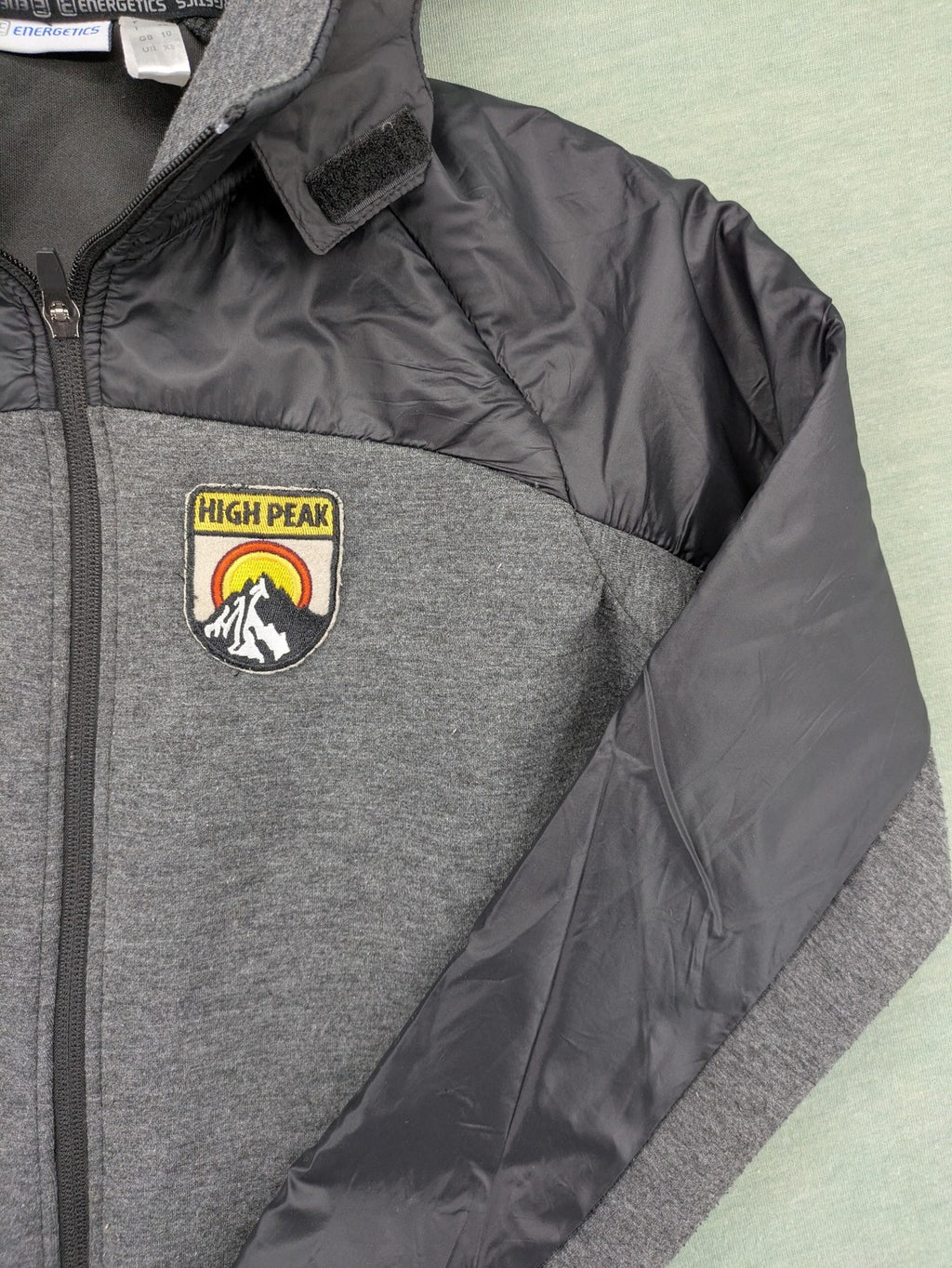 Energetics hybrid jacket black grey with High Peak patch and zip-up design.