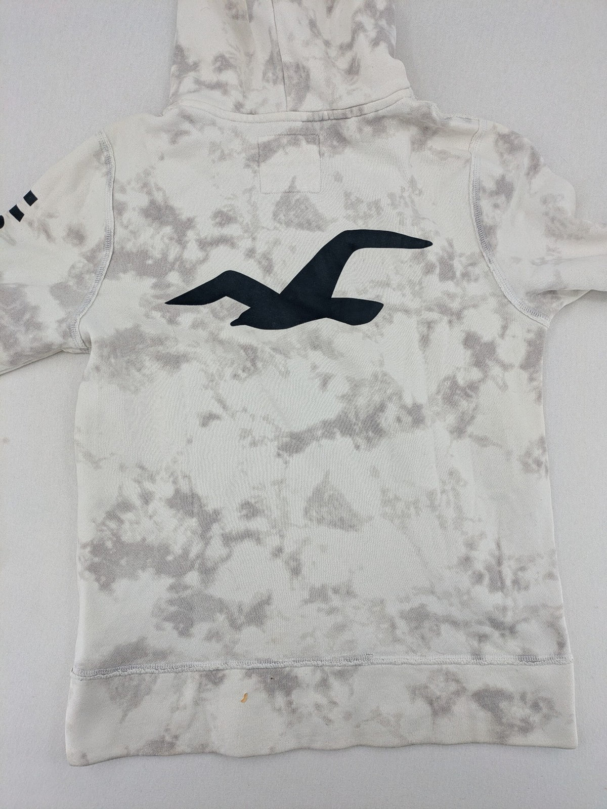 Hollister grey and white tie-dye hoodie with logo on chest, back, and sleeve.