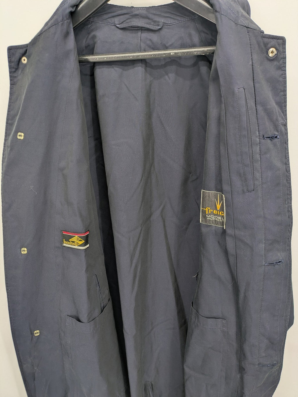 Freic navy trench coat single-breasted design with elegant collar and buttoned flap pockets.