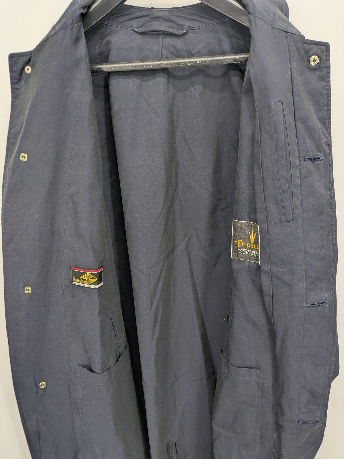 Freic navy trench coat single-breasted design with elegant collar and buttoned flap pockets.