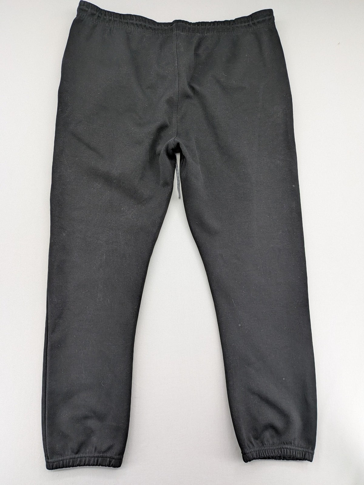 K1X grey joggers with white basketball logo, elastic waistband, and cuffed ankles.