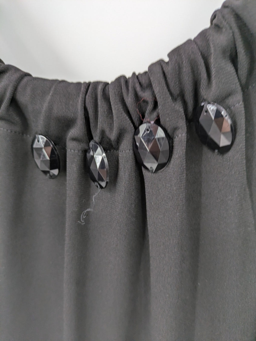 En Focus Studio beige and black top, sleeveless with beaded neckline and tie detail.