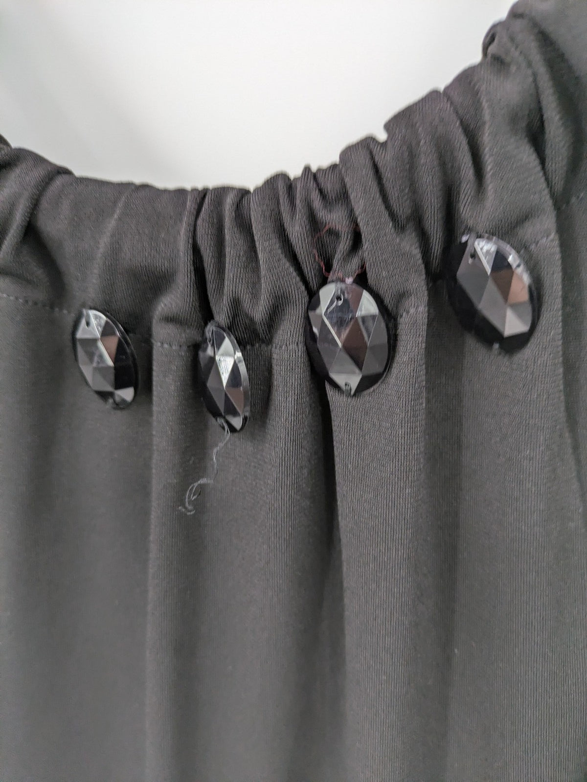 En Focus Studio beige and black top, sleeveless with beaded neckline and tie detail.
