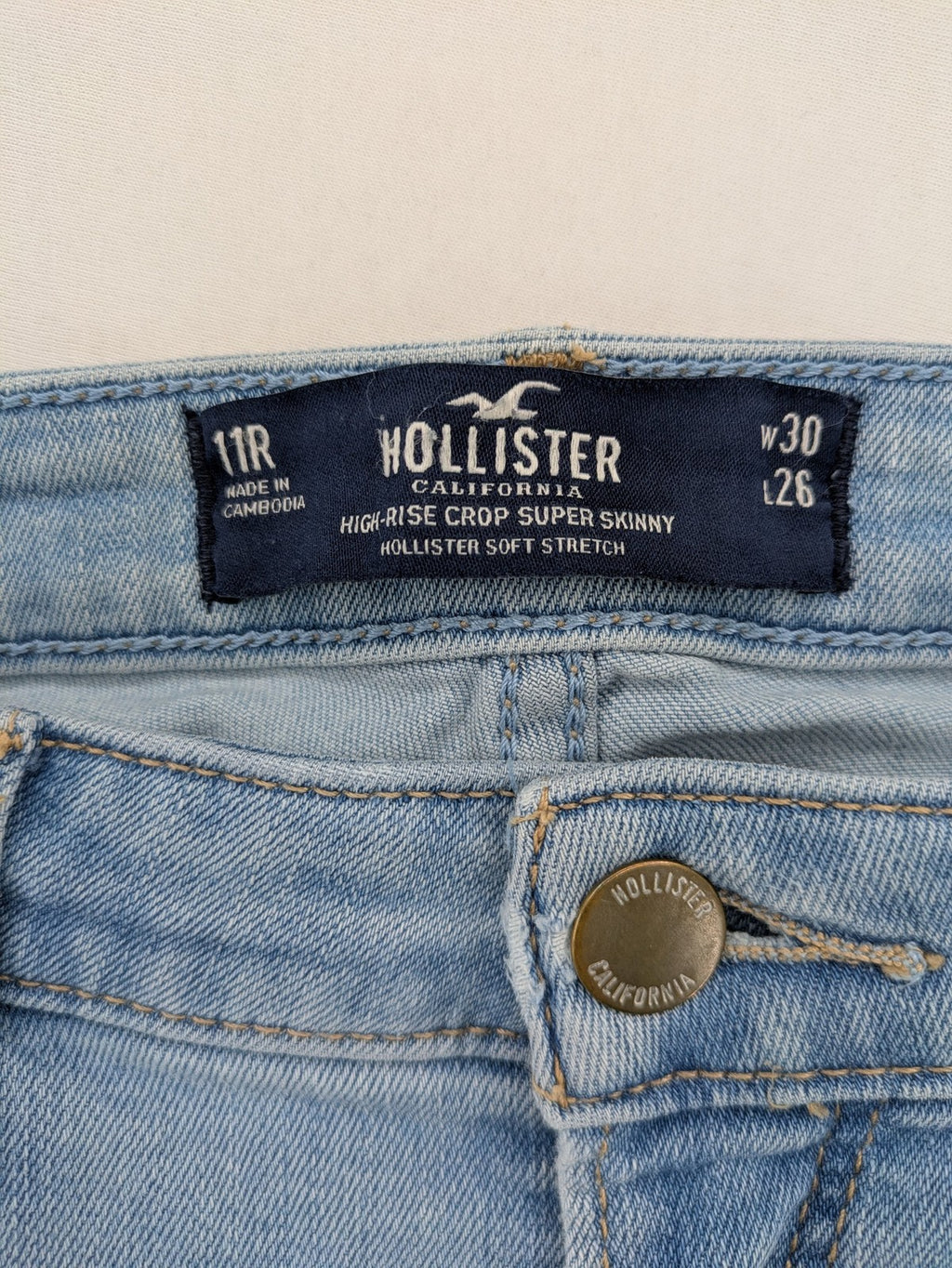 Hollister blue high-rise crop super skinny jeans with distressed rips and frayed hem.
