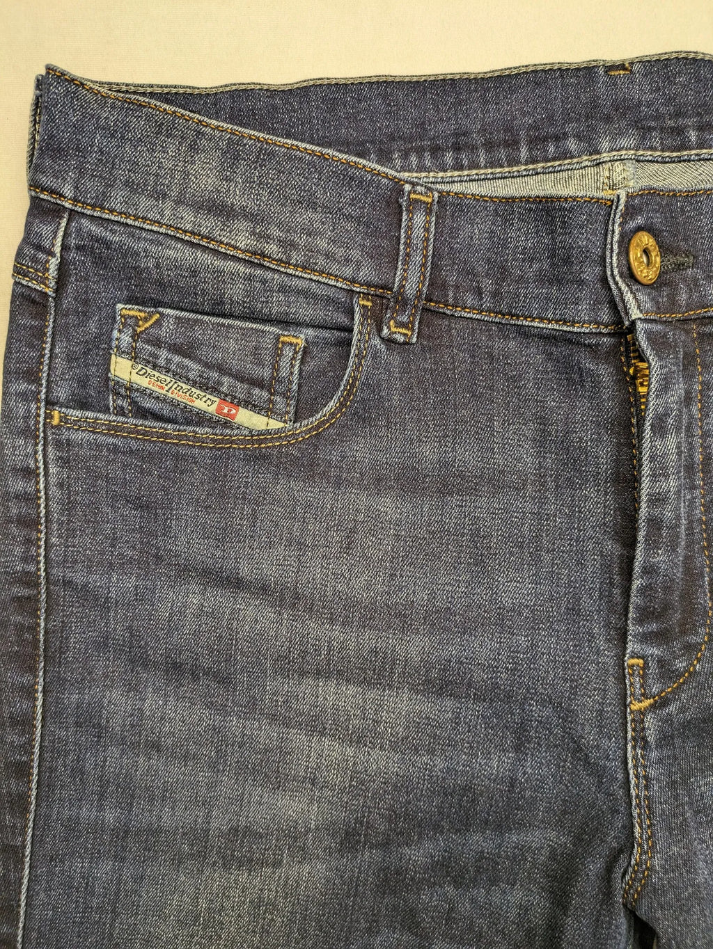 Diesel blue straight jeans with regular waist, dark wash, and stretch material.
