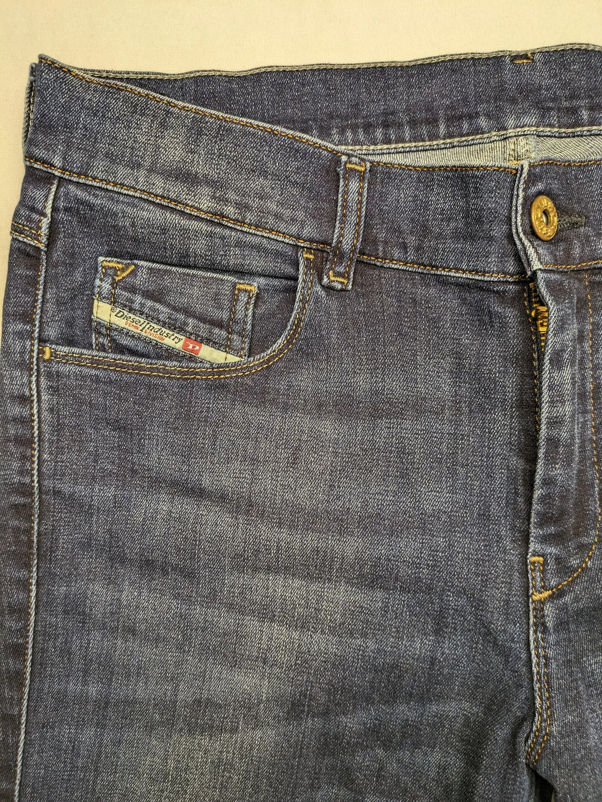 Diesel blue straight jeans with regular waist, dark wash, and stretch material.