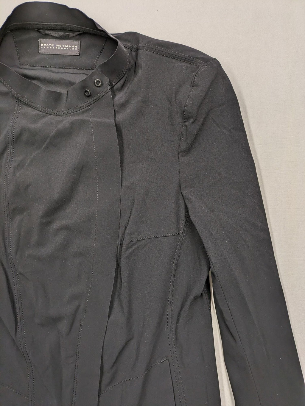 Beate Heymann black biker jacket with asymmetrical front and stand-up collar, stretch material.
