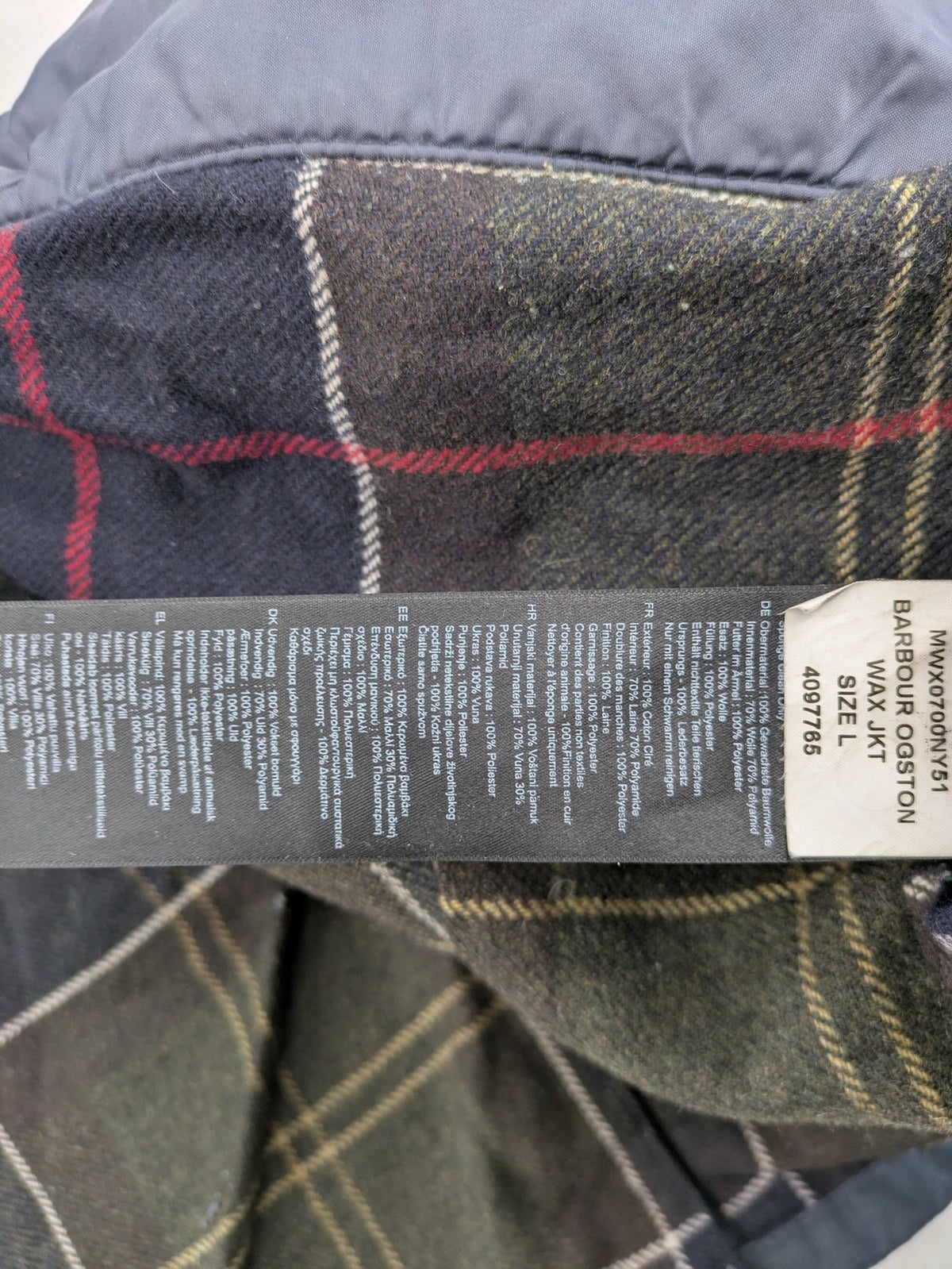 Barbour navy wax jacket with quilted lining and leather elbow patches, tartan interior.