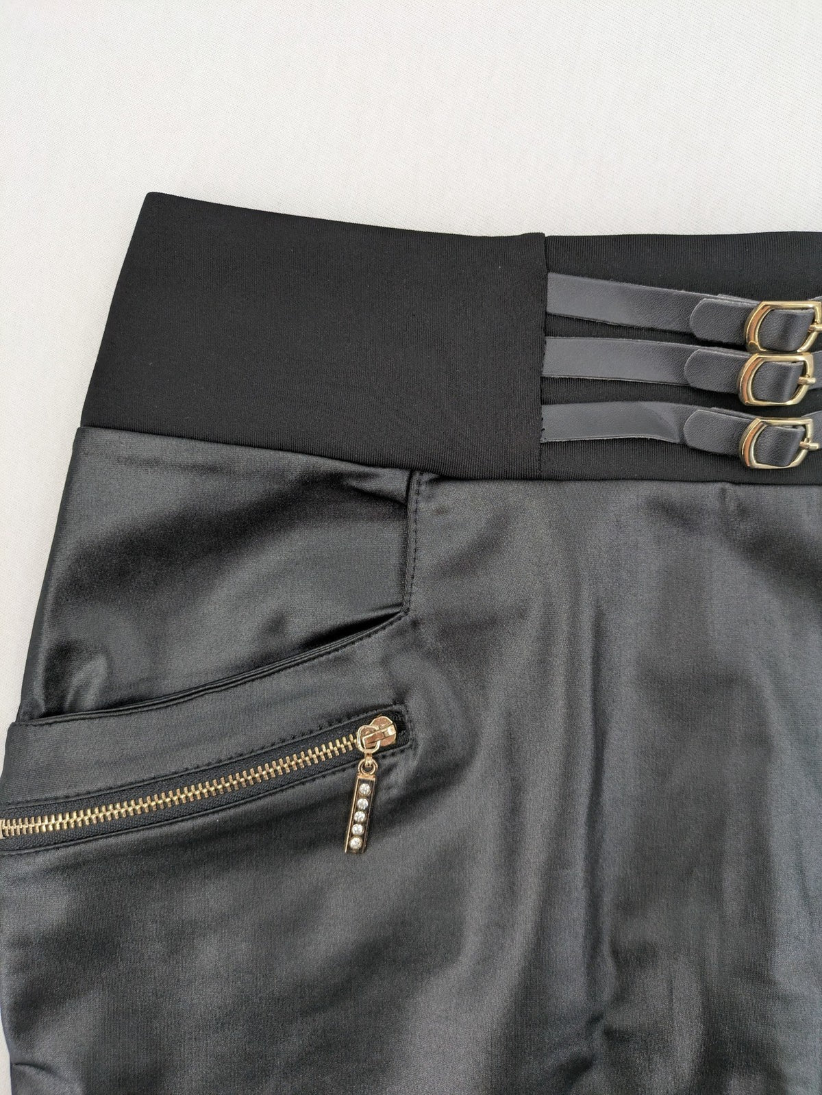 Romatie black mini bodycon skirt satin finish high waist with gold zippers and buckles.