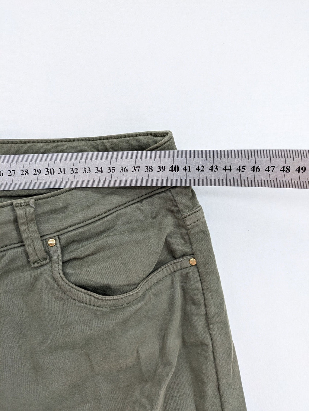 Maison 123 green cargo pants with ankle zippers and gold metal details.