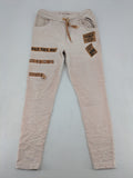 Made In Italy beige pants with crinkle texture and rock-style patches, drawstring waist.