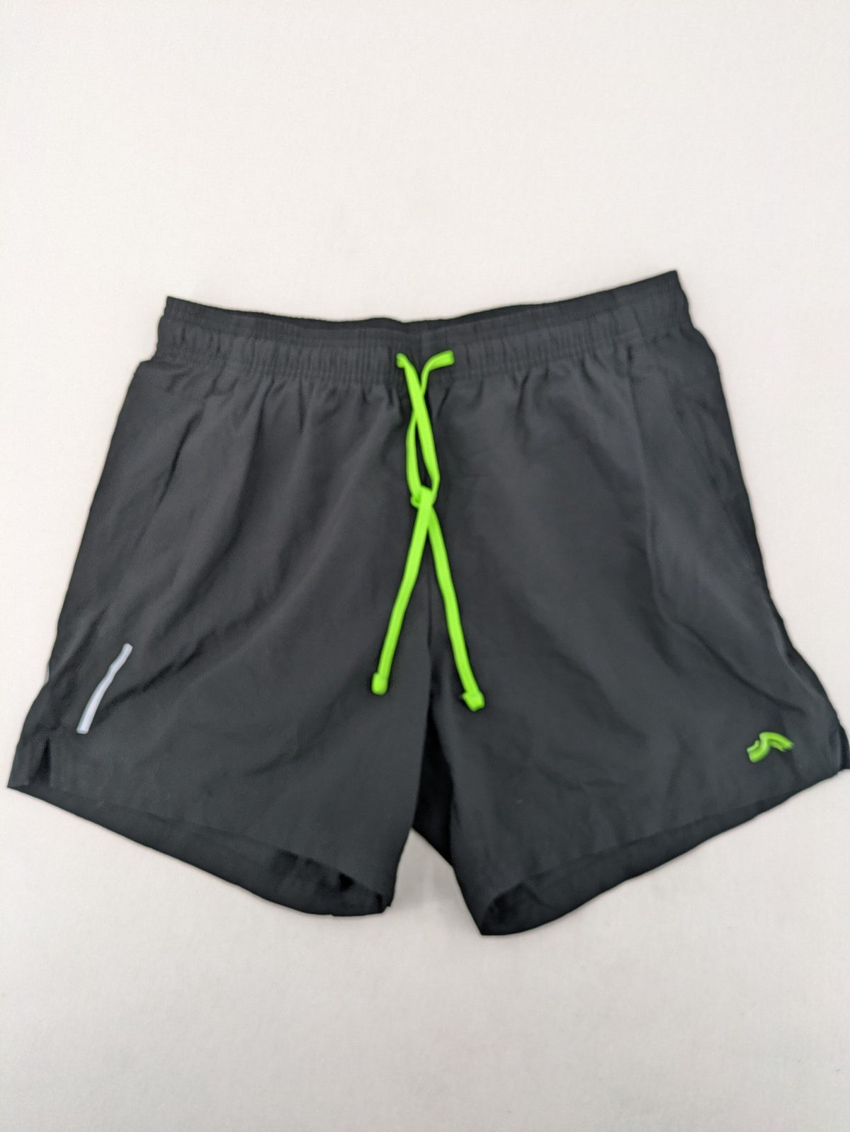 Crivit black running shorts with neon green accents, elastic waistband, and reflective details.