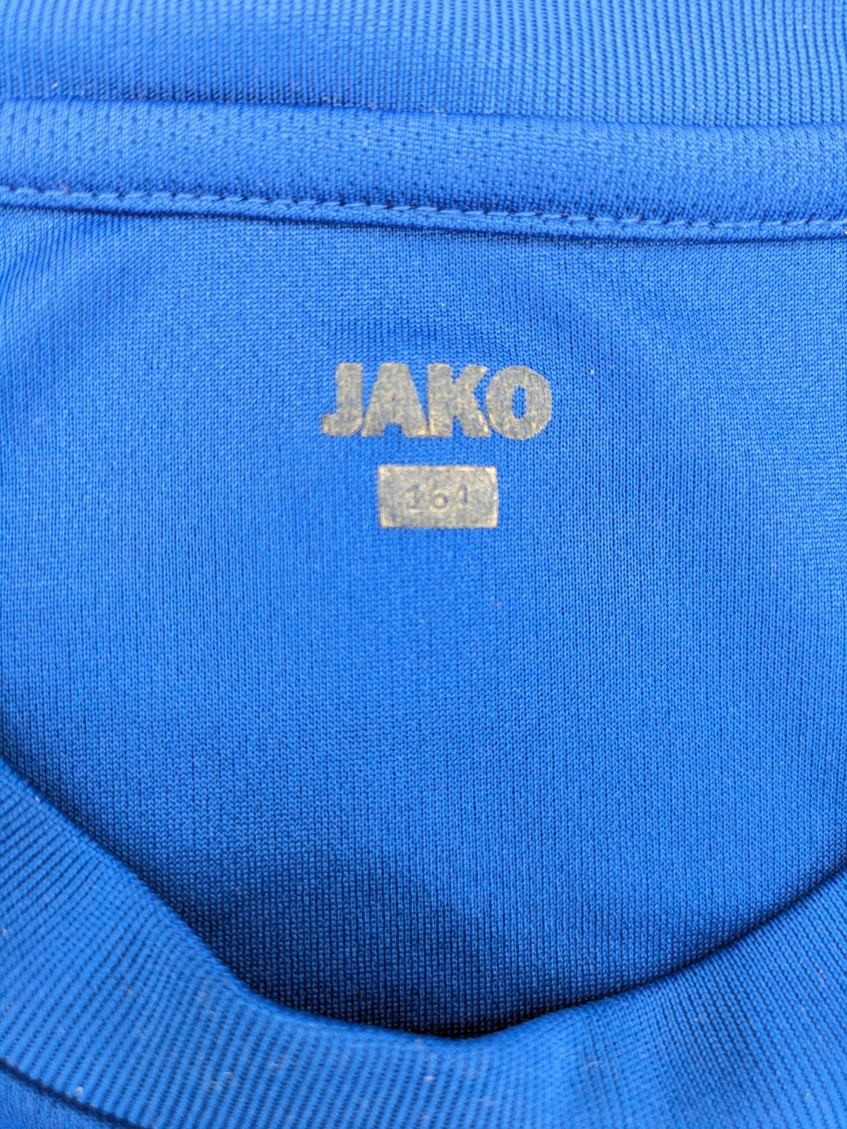 Jako blue short-sleeve training shirt with logo details and breathable polyester material.