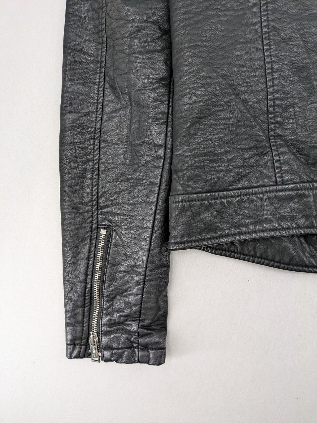 Guess black faux leather biker jacket with asymmetric zipper and multiple zip pockets.