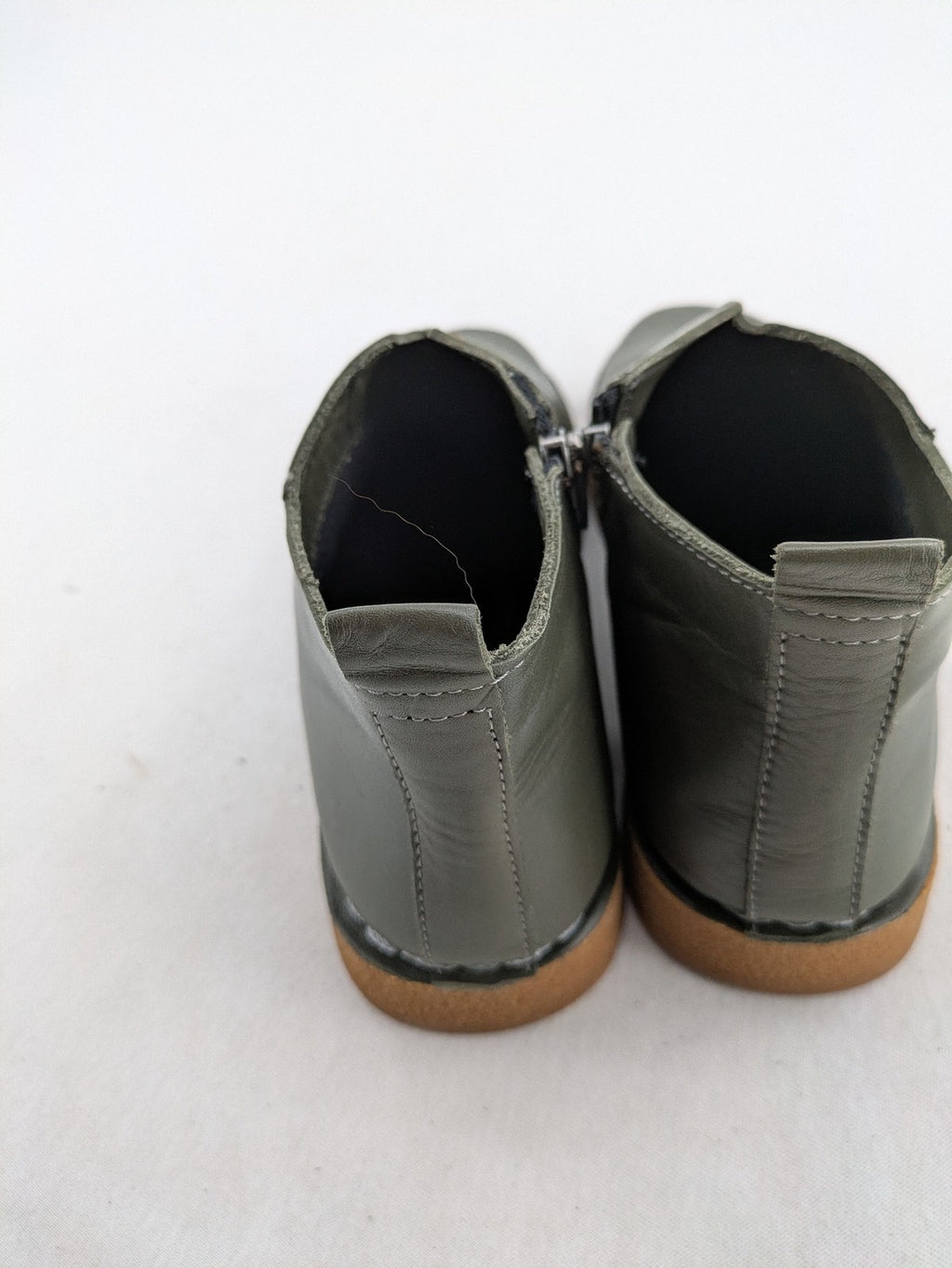 ALS green leather booties with side zipper and decorative stitching.