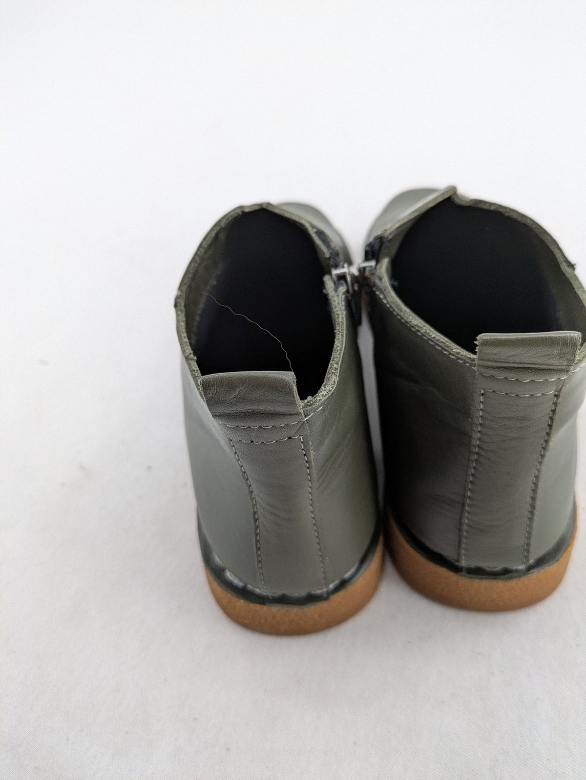 ALS green leather booties with side zipper and decorative stitching.