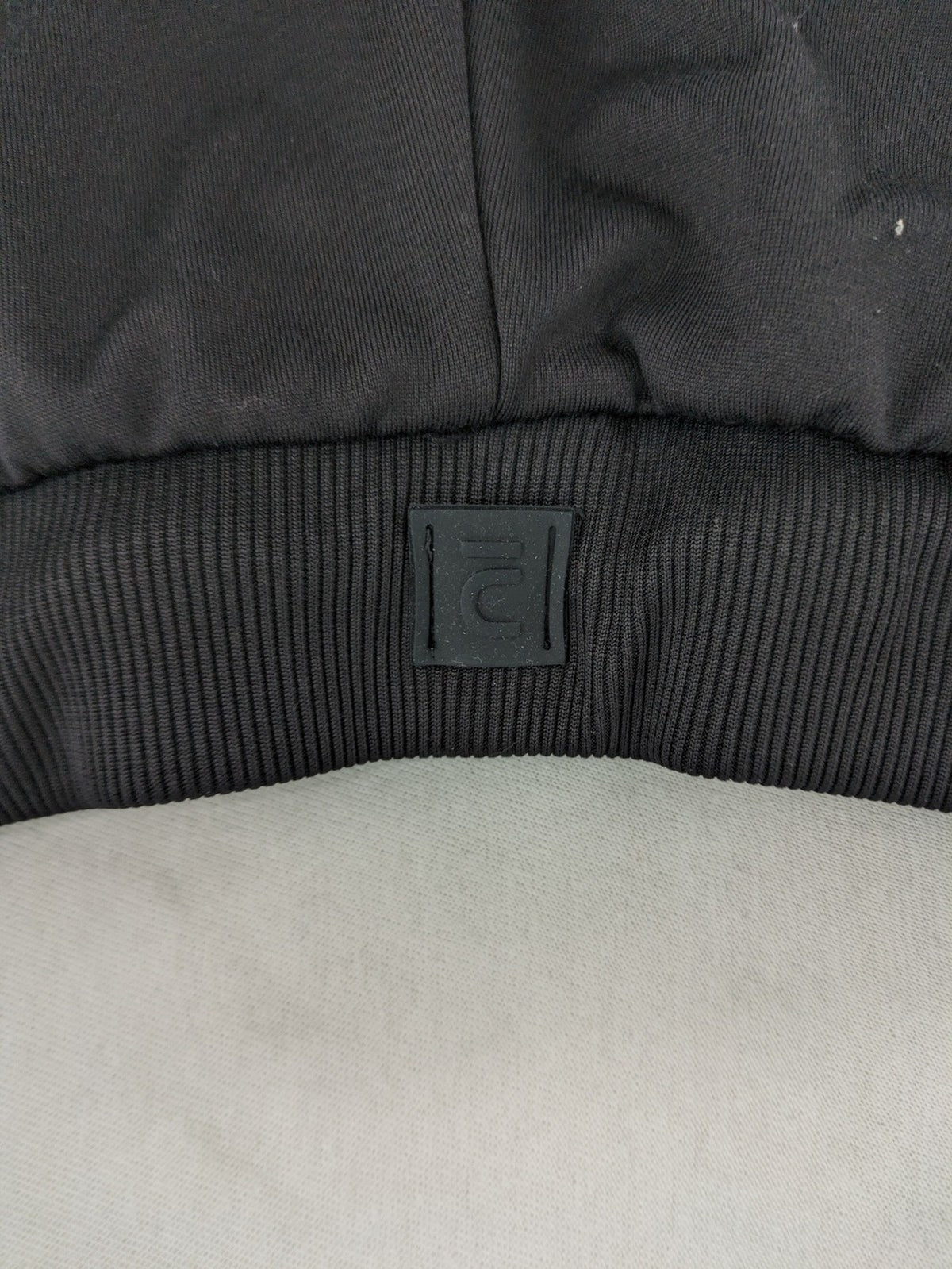 Kalenji black loungewear pants with grey accents and zippered side pockets.