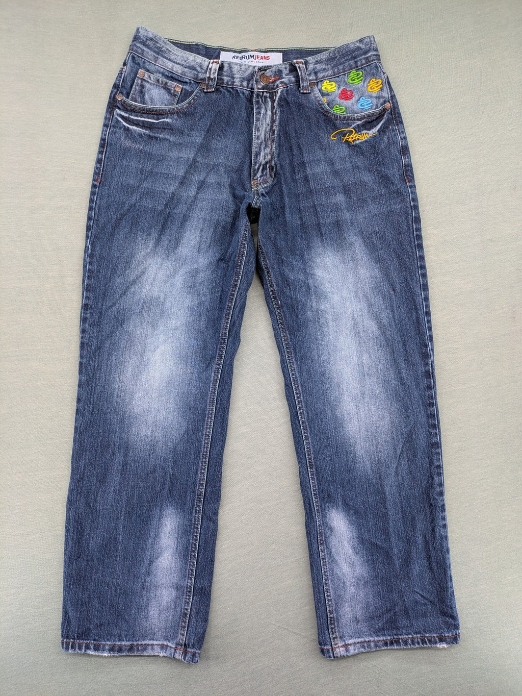 Y2K blue straight jeans with colorful logo embroidery and baggy fit.