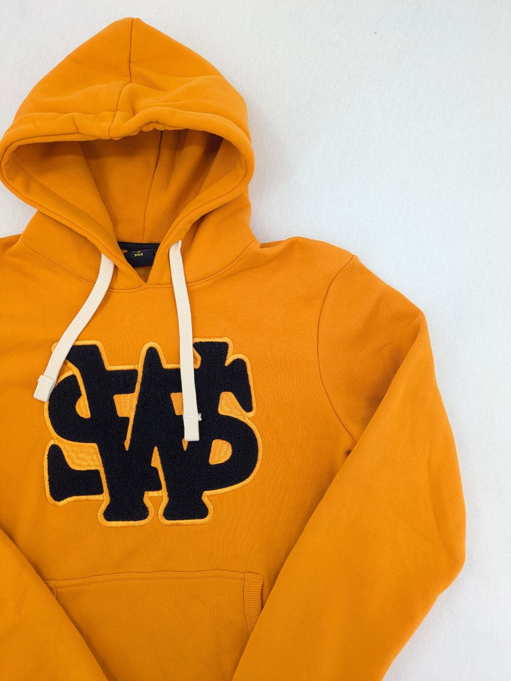 Superdry orange turtle neck jumper with textured logo patch and number 7 detail.