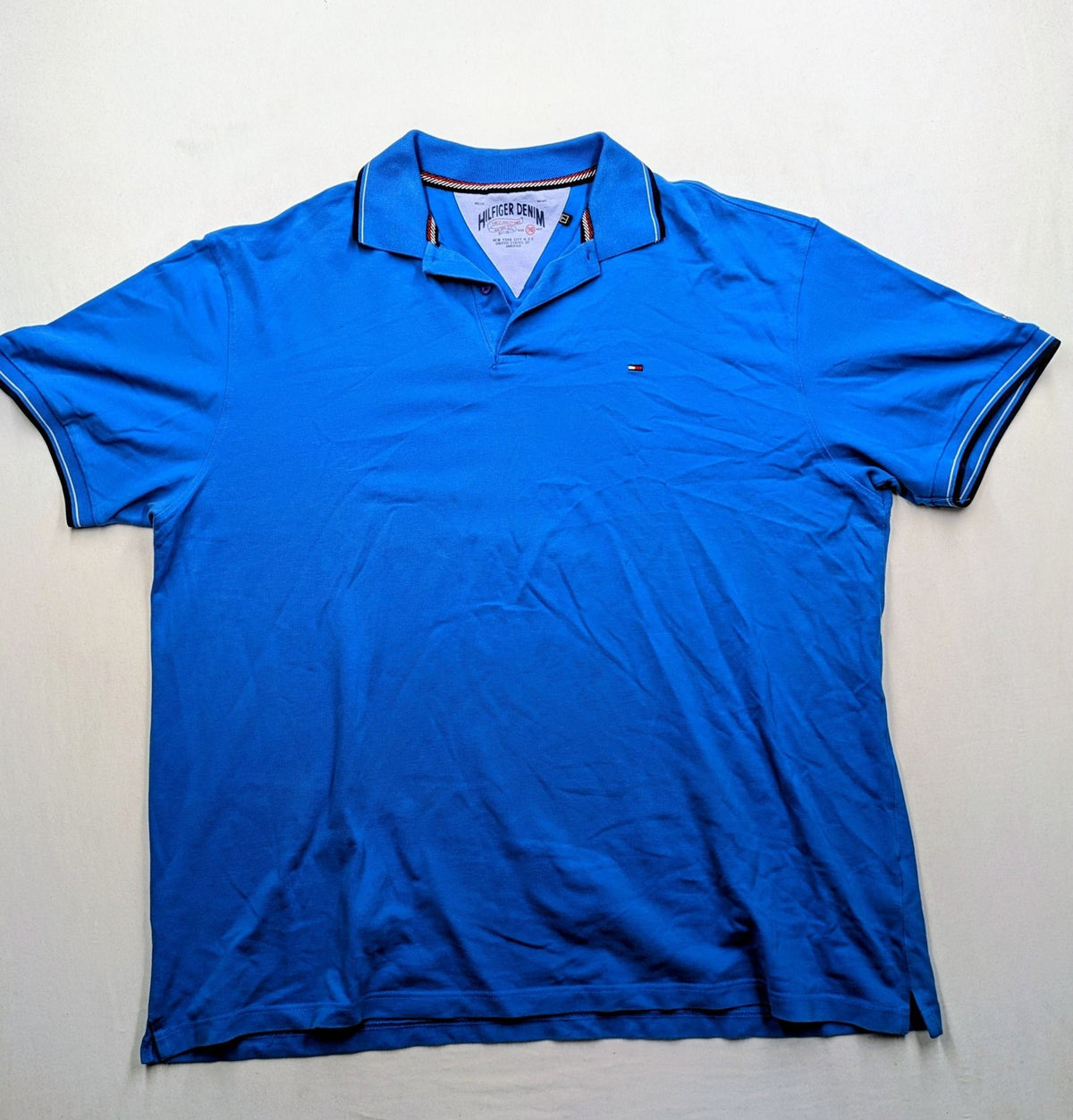 Tommy Hilfiger blue polo shirt with white stripes and embroidered logo on chest.