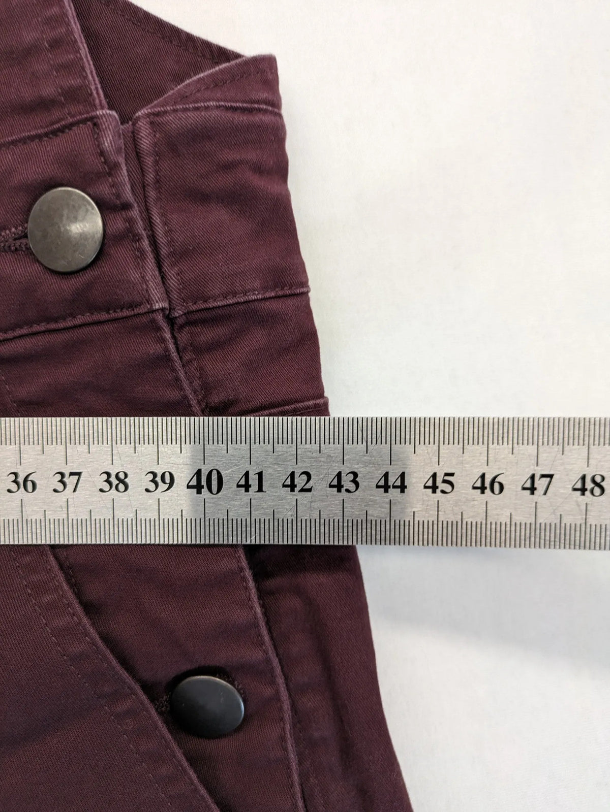 Kazane burgundy overalls with adjustable straps, side button placket, and chest pocket.