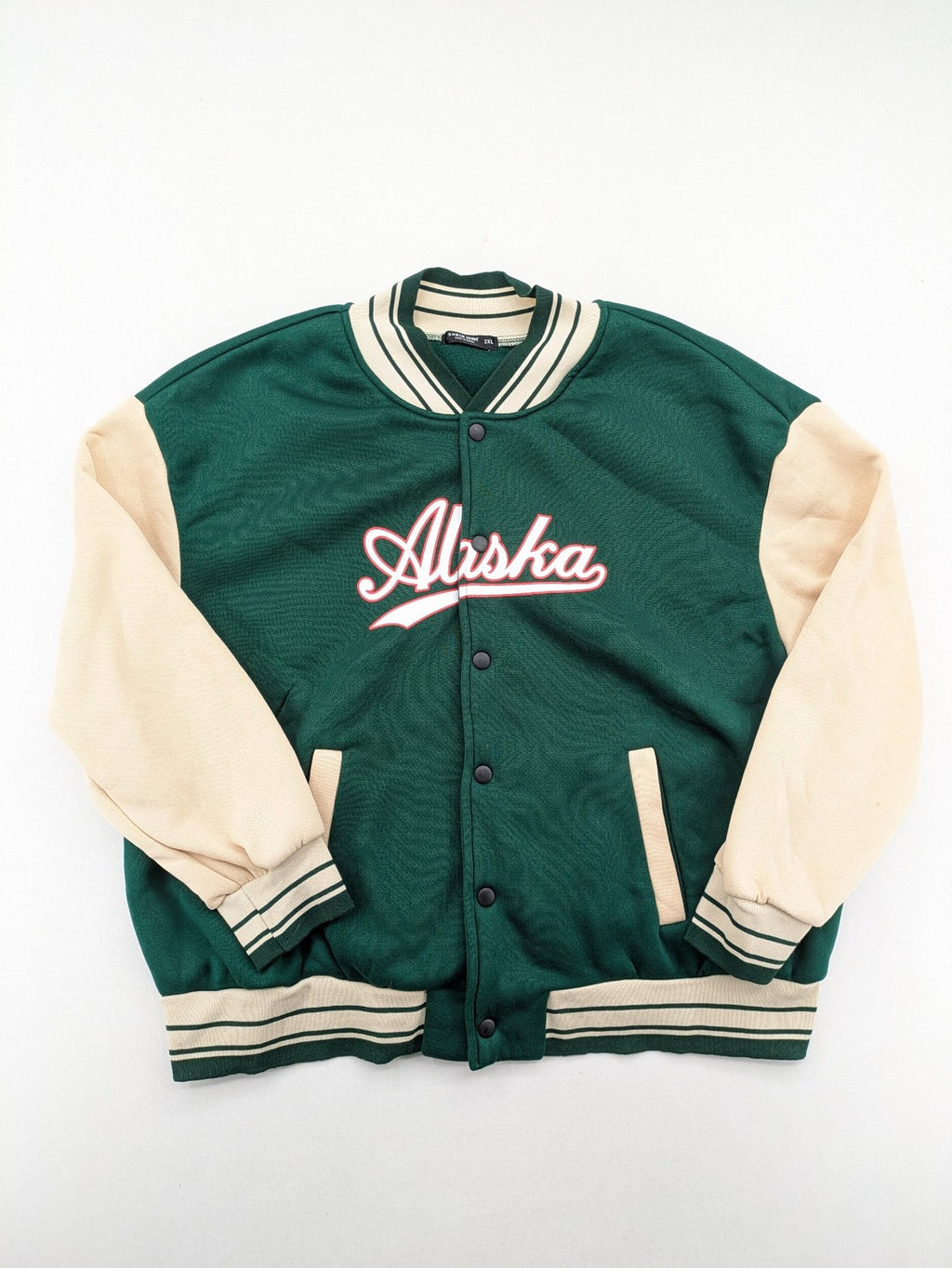 Shein Curve beige bomber jacket with green "Alaska" embroidery and striped ribbed cuffs.