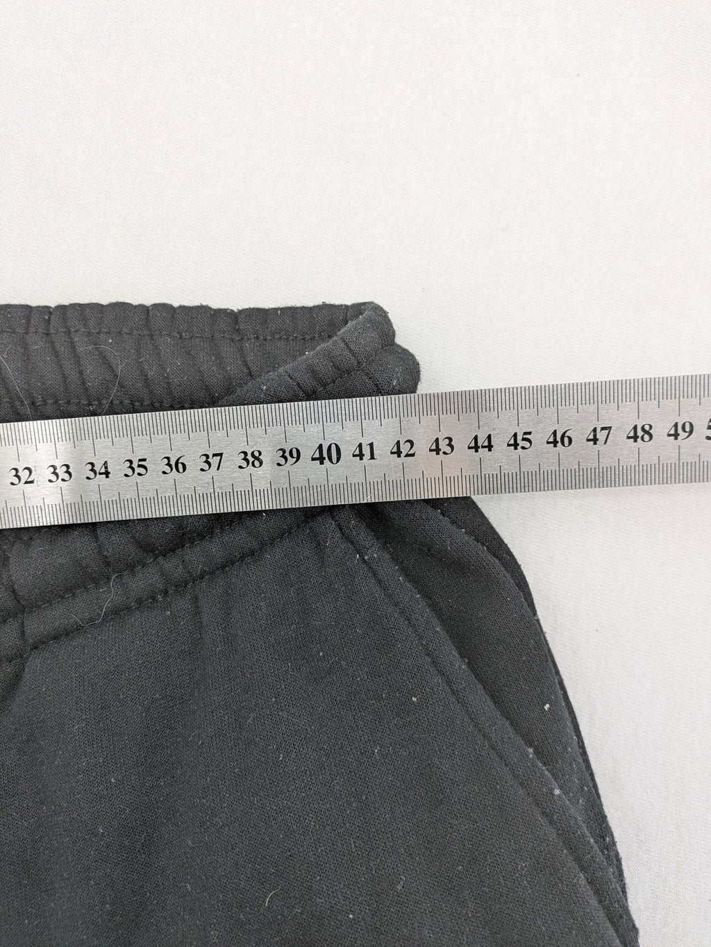 Kuyruun black jogging pants with kangaroo logo, elastic waistband, and ribbed cuffs.