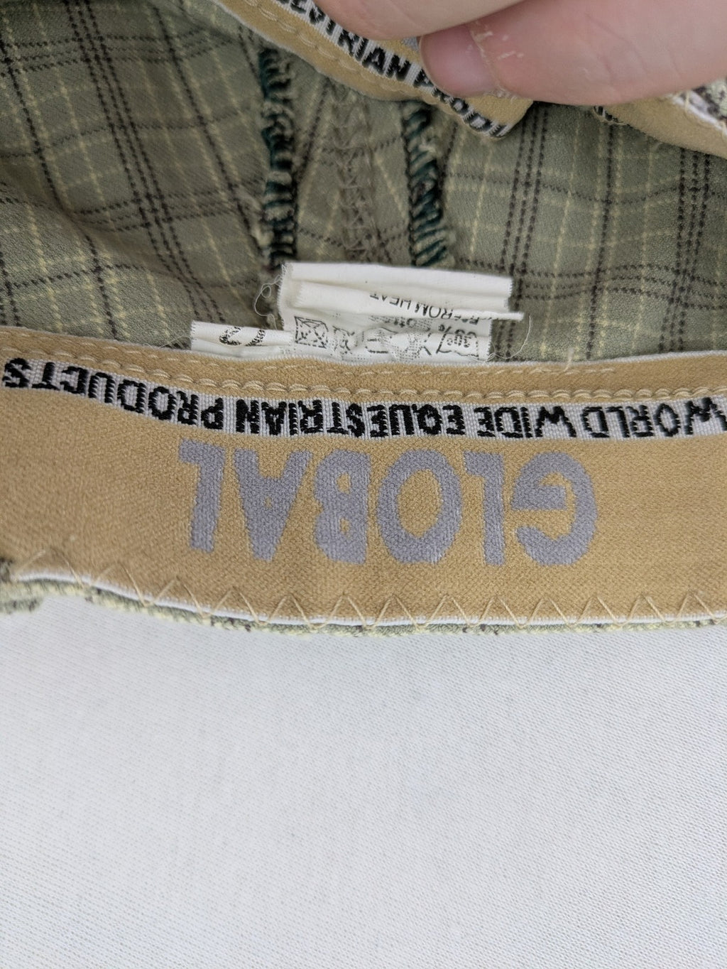 Jodhpur beige and grey riding pants with green check pattern and knee patches.