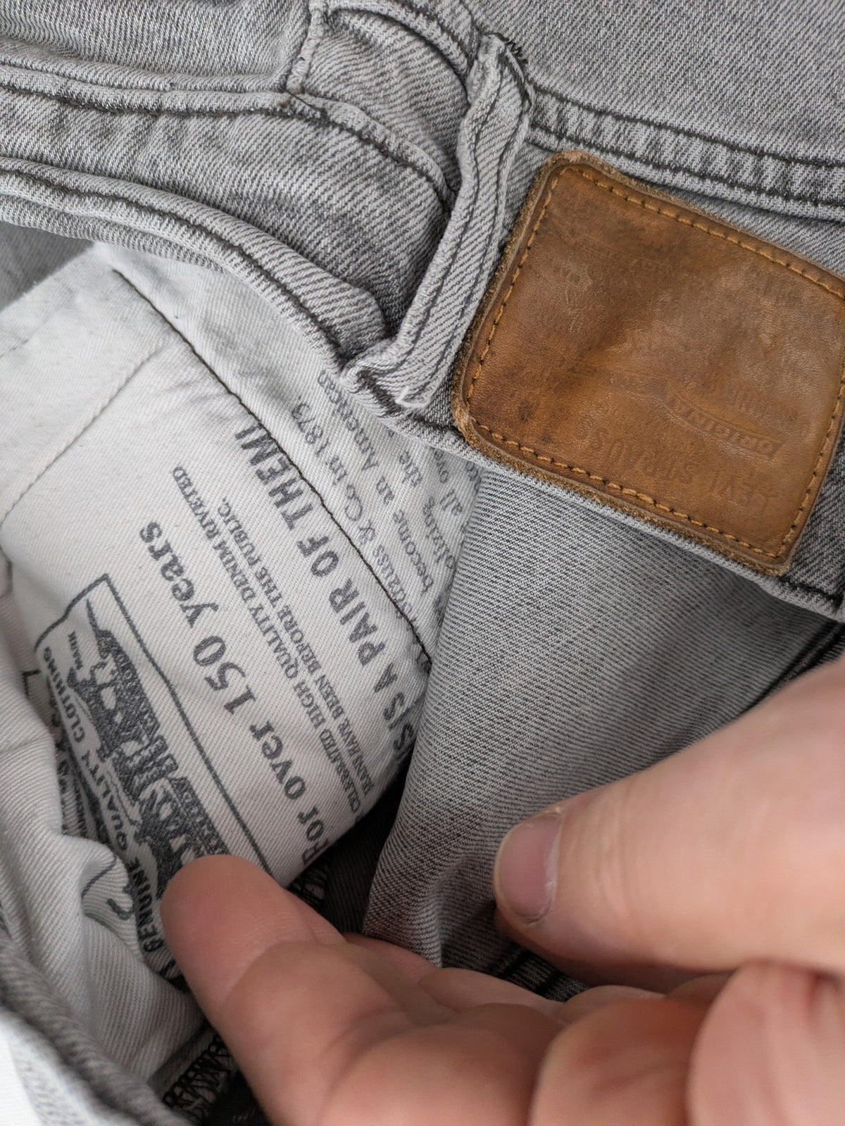Levi's grey slim fit jeans with distressed knee details and classic logo patch.