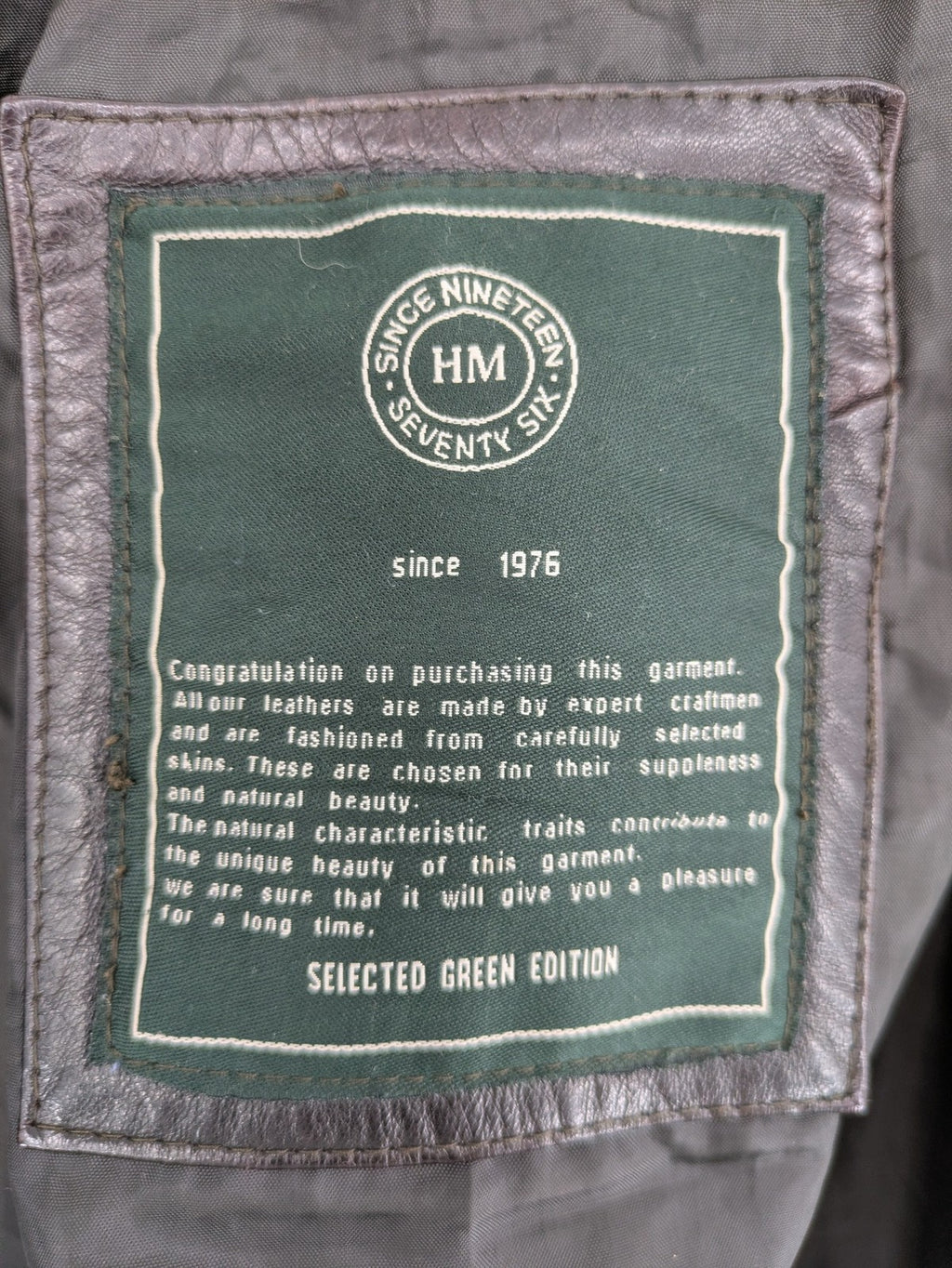 H&M green leather bomber jacket with ribbed collar and moto-style padding.