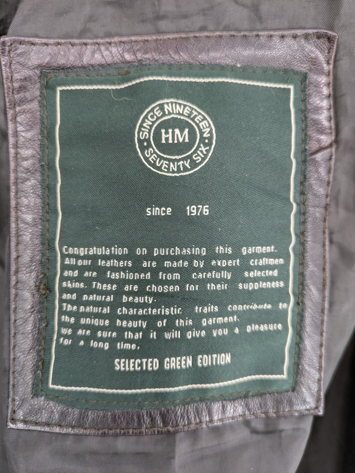H&M green leather bomber jacket with ribbed collar and moto-style padding.