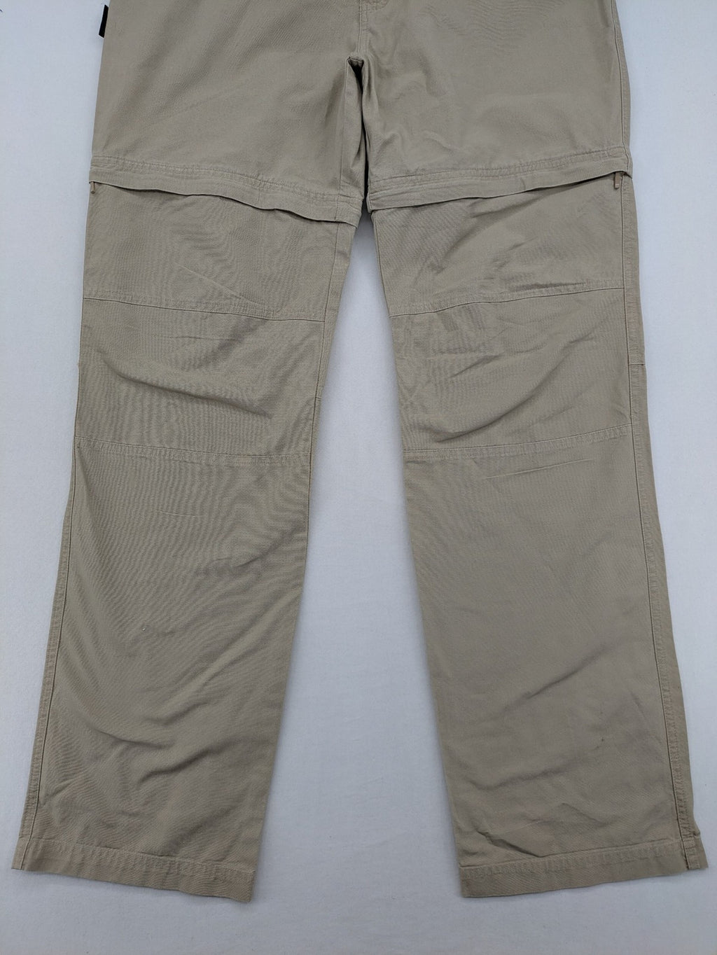 Quechua khaki convertible hiking pants with zip-off legs and durable cotton fabric.
