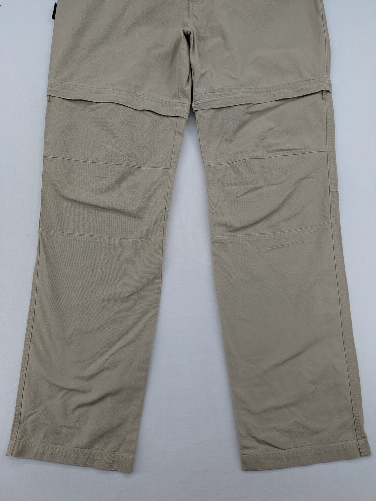 Quechua khaki convertible hiking pants with zip-off legs and durable cotton fabric.