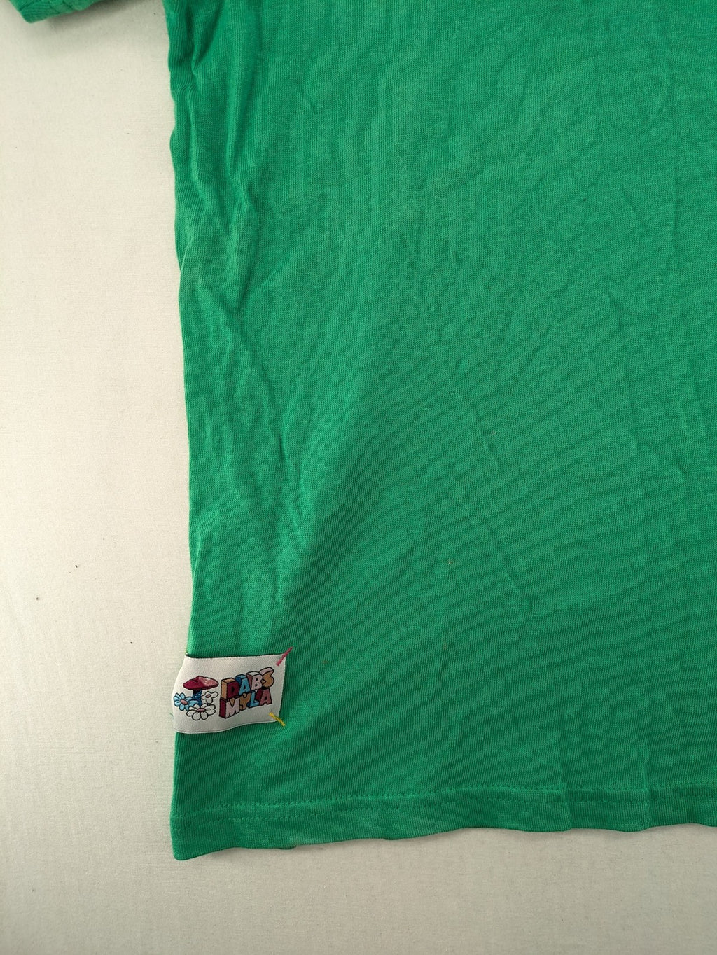 Myla green graphic t-shirt with large peace earth print and front pocket design.