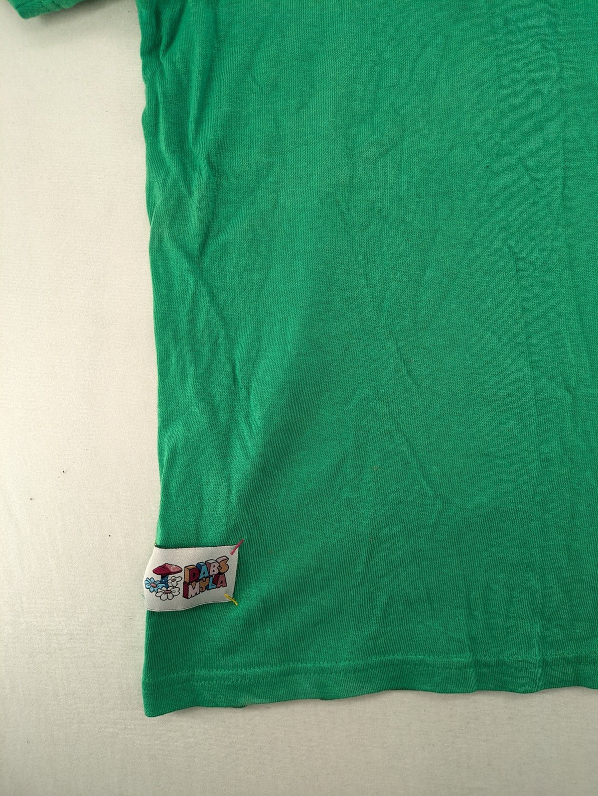 Myla green graphic t-shirt with large peace earth print and front pocket design.