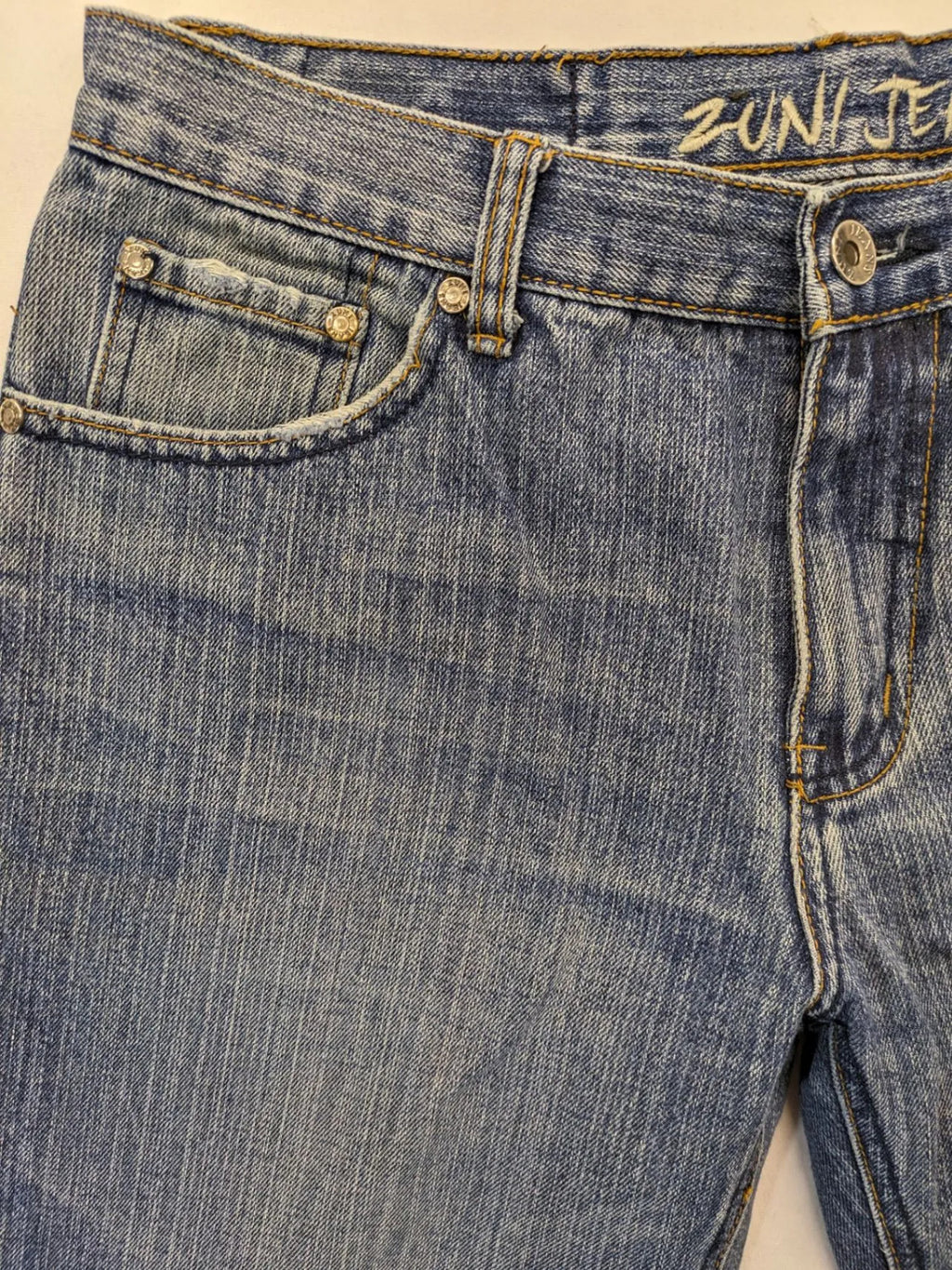 Zuni blue straight jeans 5-pocket design with zipper and decorative rivets.