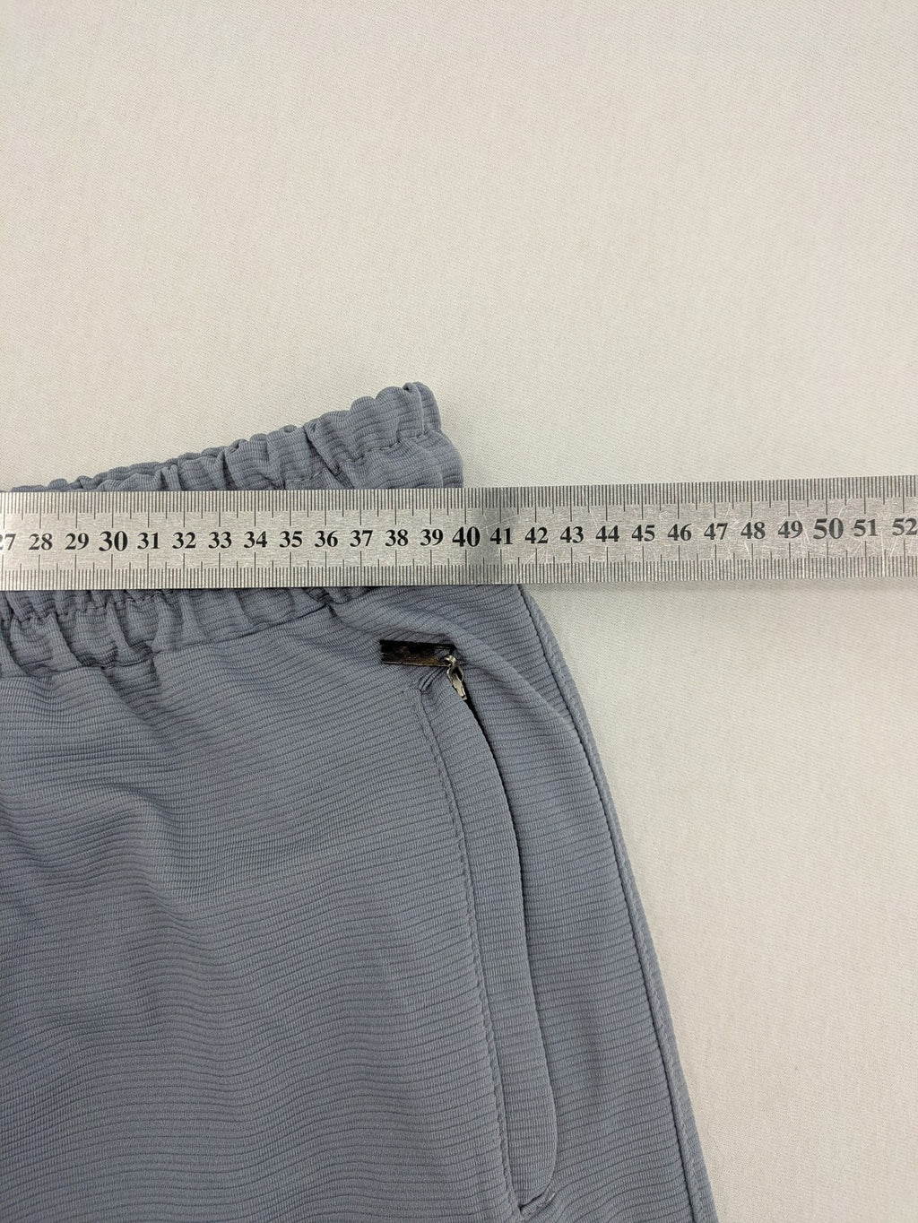 Nike grey shorts with Dri-FIT technology, elastic waistband, and zippered pockets.