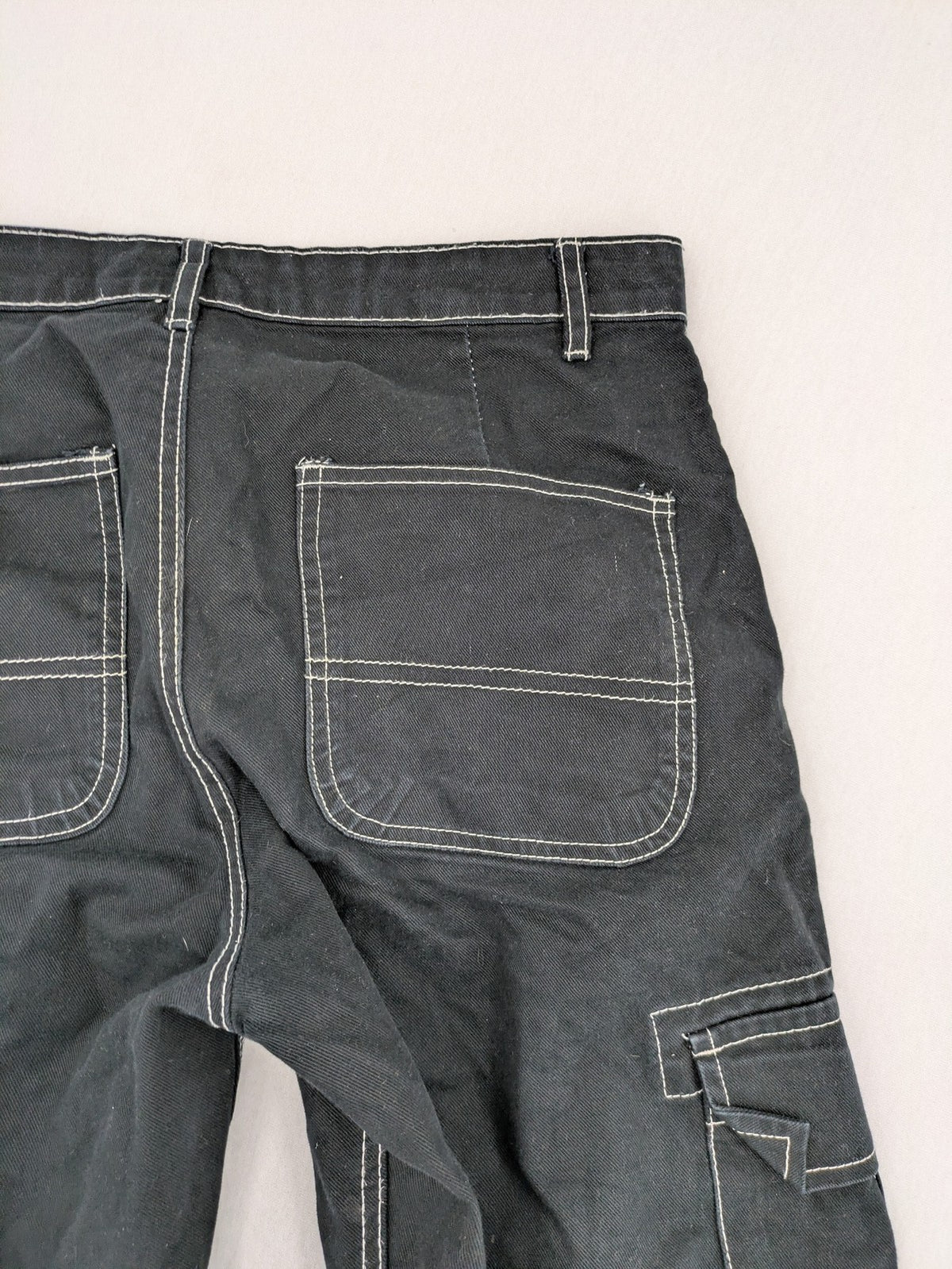 FSBN black baggy cargo pants with white contrast stitching and multiple pockets.