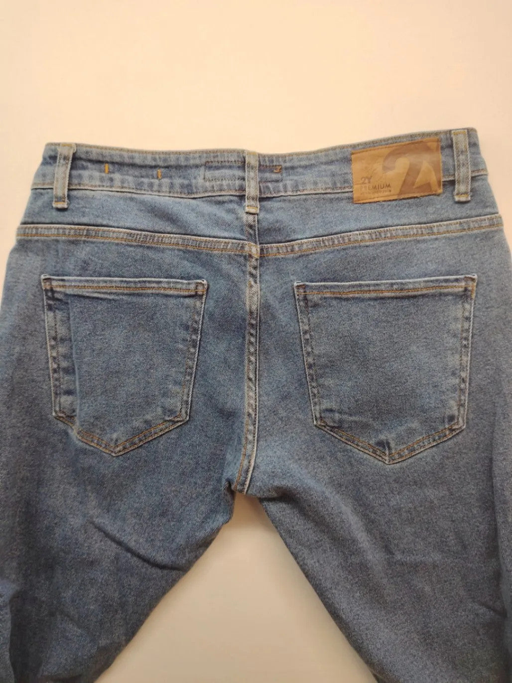 Damen blue skinny jeans with ripped details, five-pocket style, and classic button closure.