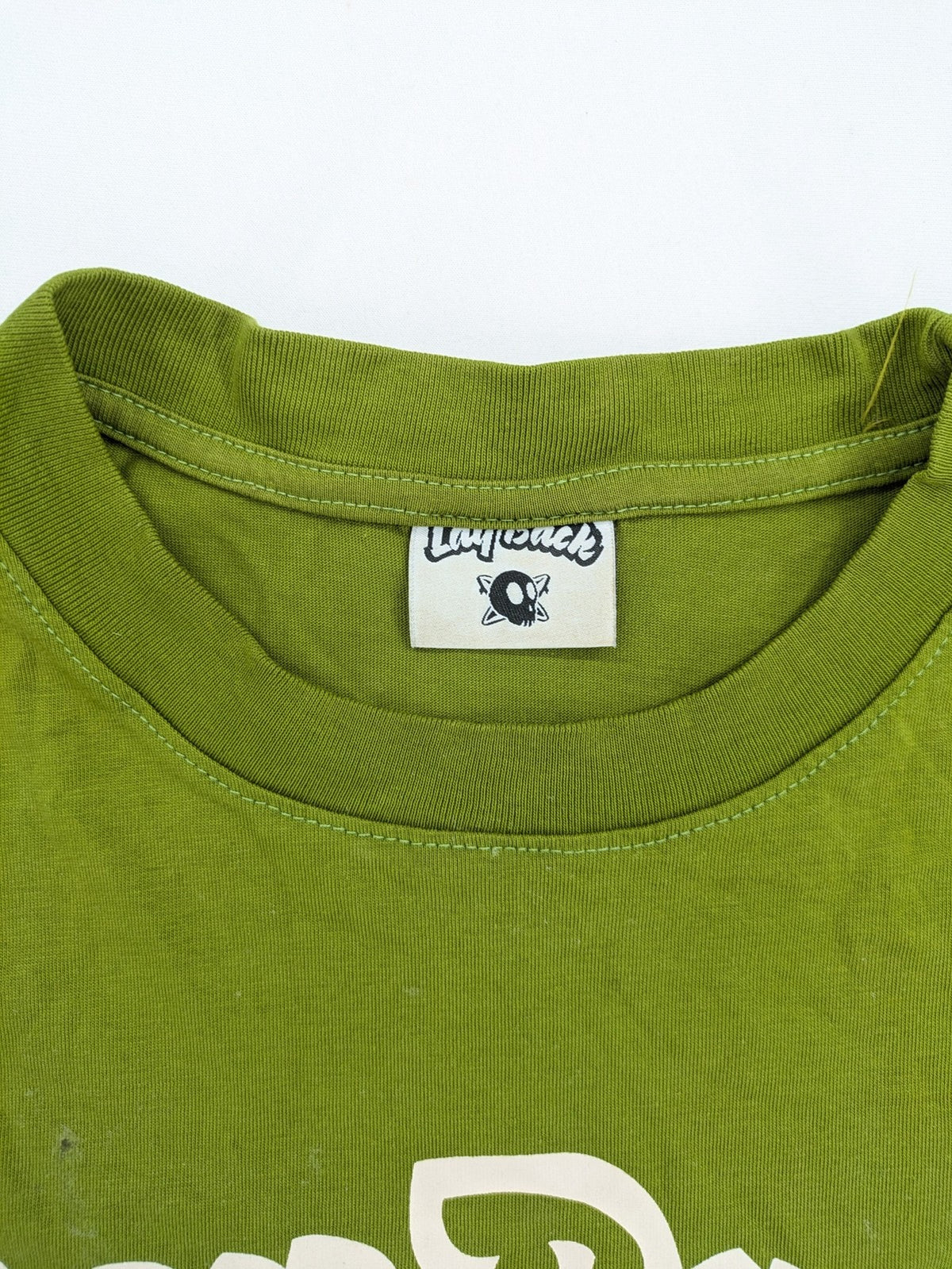Lay Back green t-shirt with skull graphic, logo print, and short sleeves.