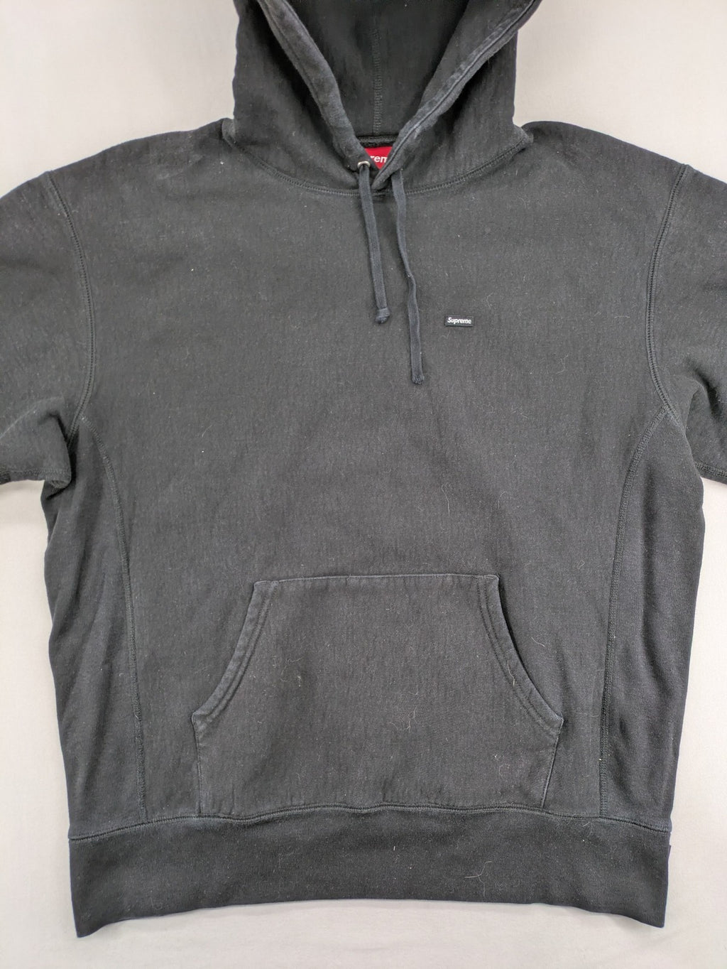 Supreme grey hoodie with embroidered small box logo, kangaroo pocket, and ribbed cuffs.
