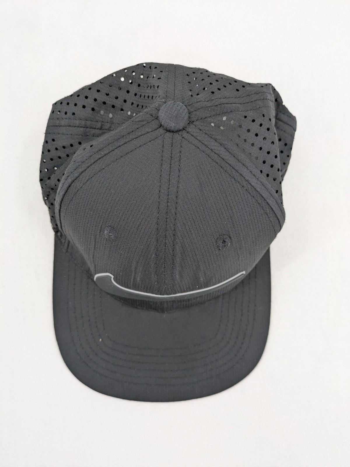 Nike Heritage86 black snapback cap with perforated design and prominent Swoosh logo.