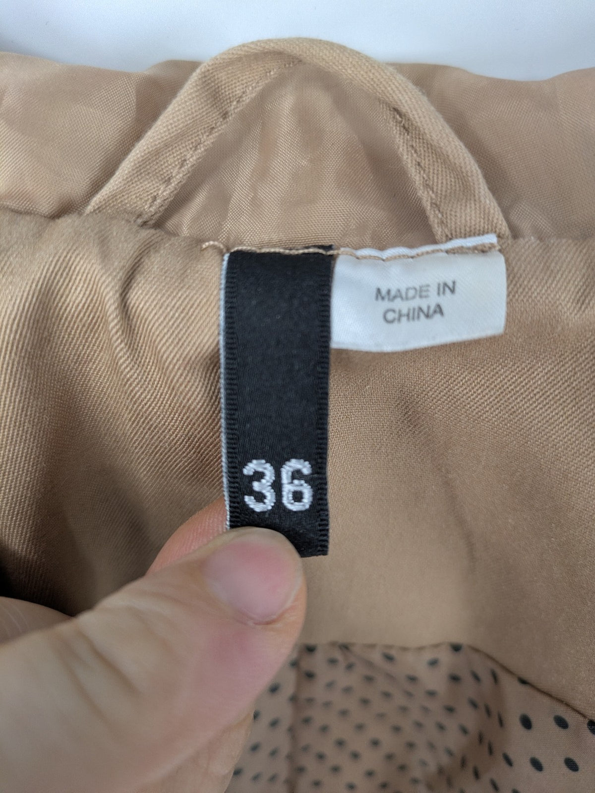 H&M Divided beige trench coat with button closure, hood, and polka dot lining.