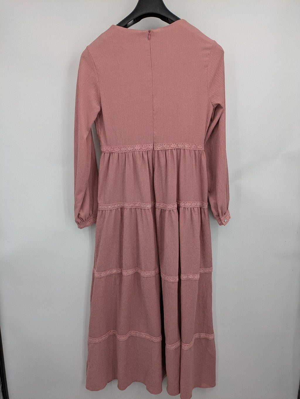 Moda pink bridal party dress with lace inserts, long sleeves, and tiered design.