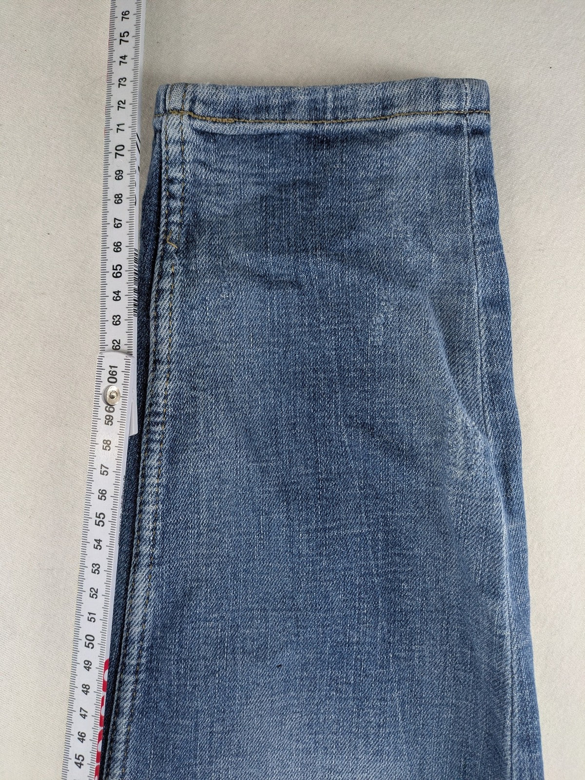 Zara blue straight jeans with distressed ripped knees and button-fly closure.